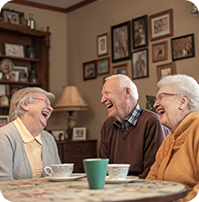 three-older-people-are-laughing-table-with-green-cup-it